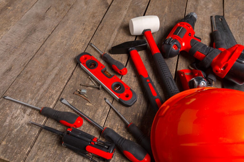 Assorted hand and power tools on wooden surface