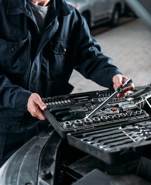 cropped view of mechanic with tool case in auto repair shop cropped view of mechanic with tool case in auto repair shop