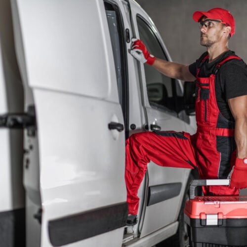 Repairman Departing After Successfully Finished Work Caucasian Middle Aged All Purpose Fixing Specialist in Red Work Wear and With a Toolbox in His Hand Getting Back Into His White Van After Successfully Completing Repair. Professional Handyman Services.